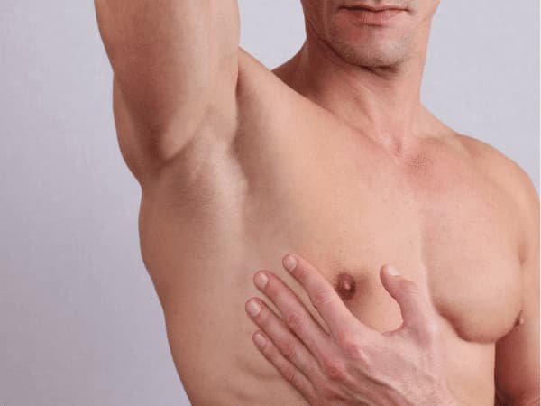 Uomo sportivo che solleva il braccio mostrando petto e ascella, esempio di depilazione per sportivi per migliorare igiene e performance.